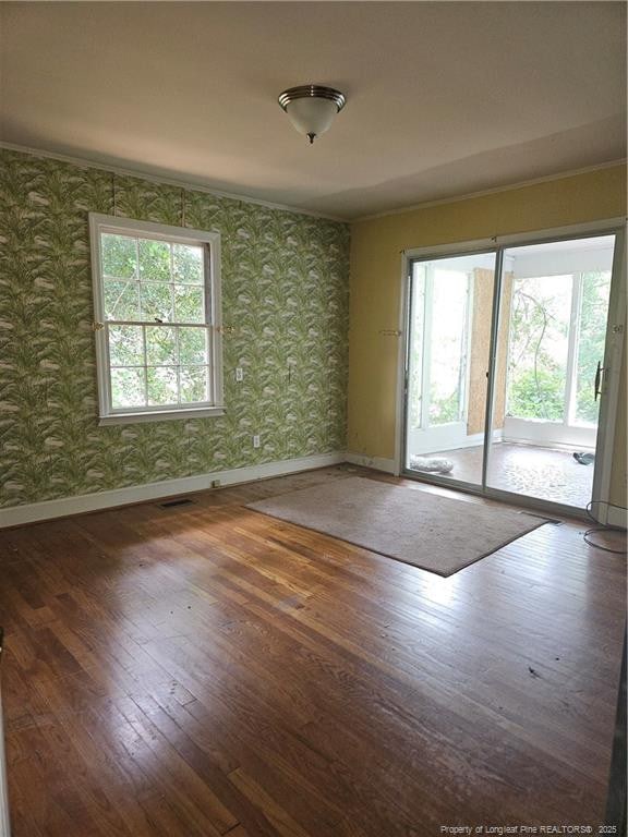 2943 Ole Bluff Mill Rd, Fayetteville, NC 28306 - empty room with wallpapered walls, plenty of natural light, and wood-type flooring