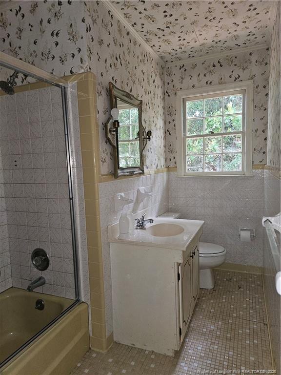 2943 Ole Bluff Mill Rd, Fayetteville, NC 28306 - full bathroom featuring wallpapered walls, tile patterned floors, vanity, tile walls, and shower / bath combination with glass door