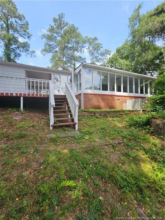 2943 Ole Bluff Mill Rd, Fayetteville, NC 28306 - rear view of property featuring a sunroom, stairs, brick siding, and a wooden deck