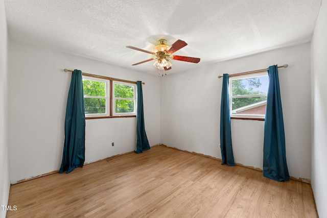218 Forestville Rd, Wake Forest, NC 27587 - unfurnished room featuring light wood finished floors, plenty of natural light, a ceiling fan, and a textured ceiling