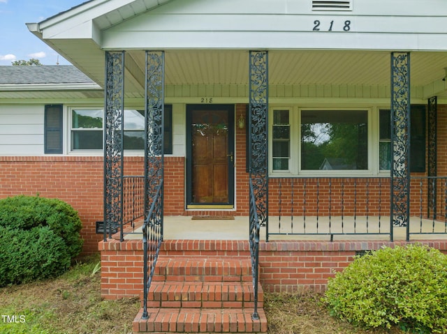 218 Forestville Rd, Wake Forest, NC 27587 - view of exterior entry with a porch and brick siding