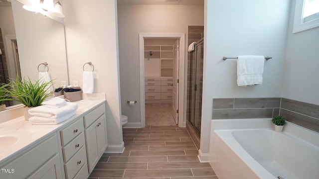 966 Airedale Trl, Garner, NC 27529 - bathroom with double vanity, a spacious closet, a shower stall, and a bath