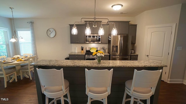 966 Airedale Trl, Garner, NC 27529 - kitchen with appliances with stainless steel finishes, a center island with sink, light stone countertops, and dark wood finished floors