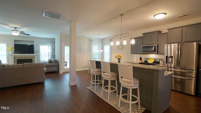 966 Airedale Trl, Garner, NC 27529 - kitchen with stainless steel appliances, gray cabinets, a kitchen bar, and plenty of natural light