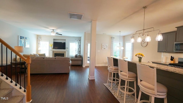 966 Airedale Trl, Garner, NC 27529 - kitchen with appliances with stainless steel finishes, gray cabinets, a breakfast bar, and plenty of natural light