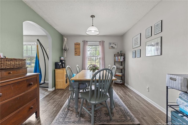 6108 Lonestar Rd, Fayetteville, NC 28303 - dining room featuring arched walkways, dark wood-style flooring, and a textured ceiling