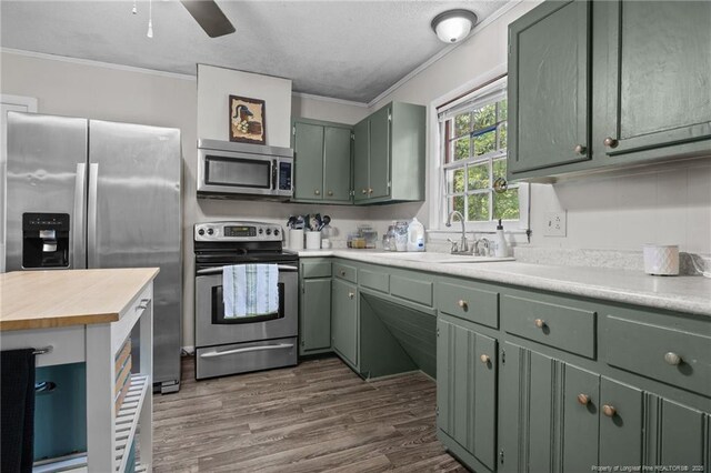 6108 Lonestar Rd, Fayetteville, NC 28303 - kitchen featuring appliances with stainless steel finishes, green cabinets, crown molding, light countertops, and ceiling fan