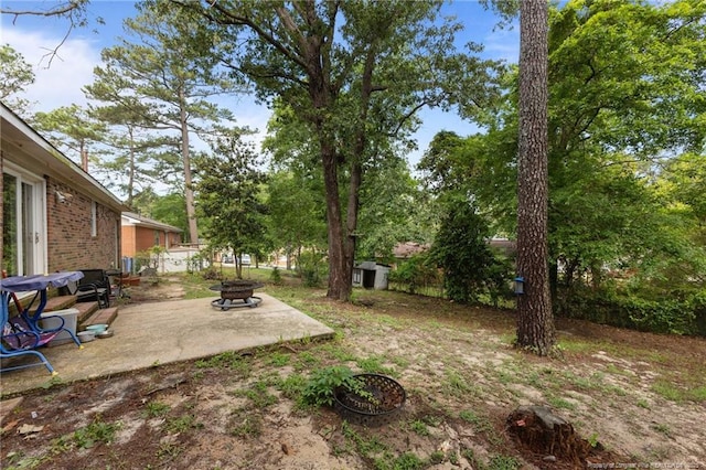 6108 Lonestar Rd, Fayetteville, NC 28303 - fenced backyard featuring a patio, an outdoor fire pit, and a storage shed