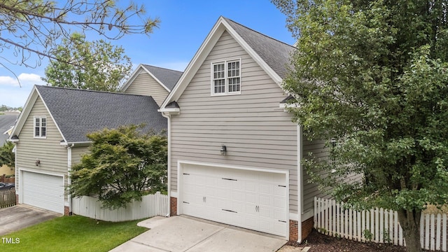 124 Kingsport Rd, Holly Springs, NC 27540 - view of side of home featuring roof with shingles, an attached garage, and driveway