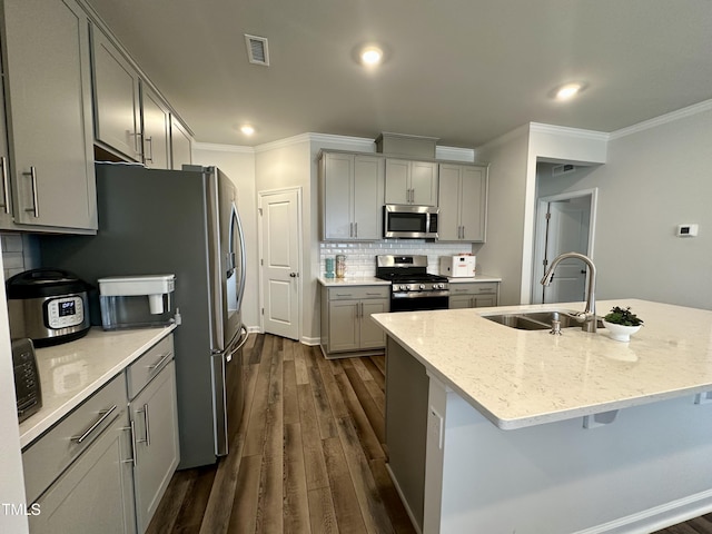 2417 Tobacco Root Dr, Raleigh, NC 27616 - kitchen featuring appliances with stainless steel finishes, gray cabinetry, crown molding, dark wood finished floors, and decorative backsplash