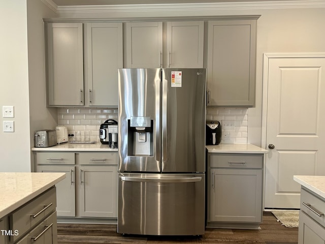 2417 Tobacco Root Dr, Raleigh, NC 27616 - kitchen with stainless steel fridge with ice dispenser, gray cabinets, tasteful backsplash, ornamental molding, and dark wood finished floors