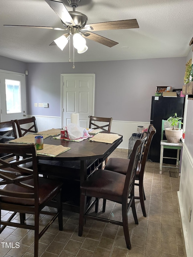 3129 Skycrest Dr, Raleigh, NC 27604 - tiled dining space with wainscoting, a textured ceiling, and ceiling fan