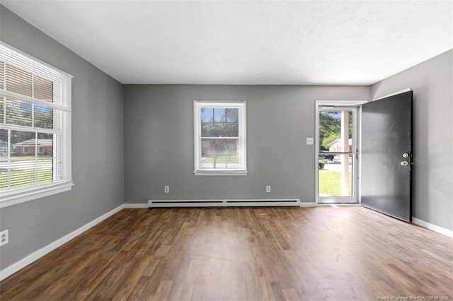 6547 Amanda Cir, Fayetteville, NC 28304 - empty room featuring a baseboard heating unit, dark wood-style floors, and healthy amount of natural light