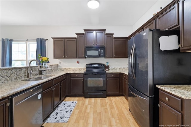 229 Red Oak Ct, Raeford, NC 28376 - kitchen featuring black appliances, light wood-type flooring, dark brown cabinetry, and light stone countertops