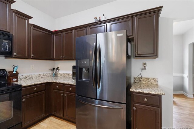 229 Red Oak Ct, Raeford, NC 28376 - kitchen featuring black appliances, light wood-type flooring, and dark brown cabinetry