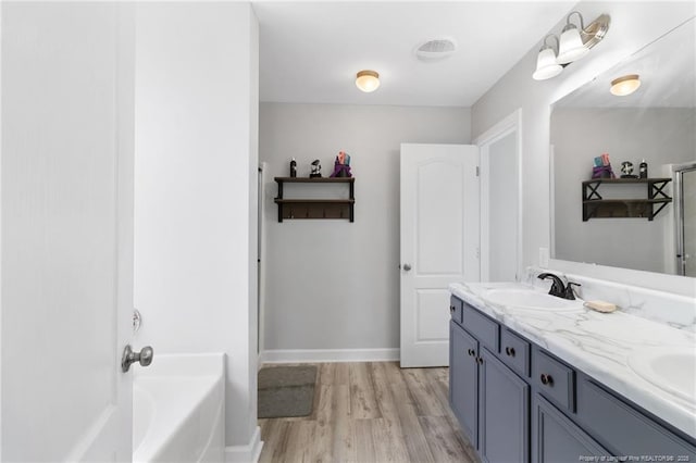 229 Red Oak Ct, Raeford, NC 28376 - full bathroom featuring wood finished floors, a bath, and double vanity