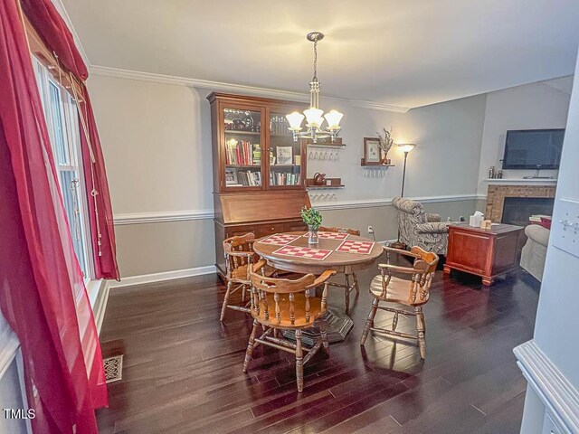 5500 Fortunes Ridge Dr Unit 94C, Durham, NC 27713 - dining space with a chandelier, dark wood-style flooring, a fireplace, and ornamental molding