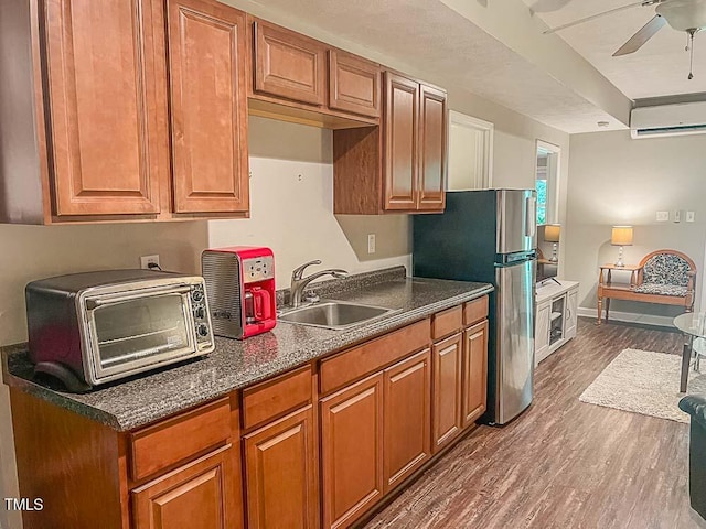5500 Fortunes Ridge Dr Unit 94C, Durham, NC 27713 - kitchen with freestanding refrigerator, a wall unit AC, wood finished floors, ceiling fan, and brown cabinets