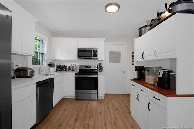 262 Shads Ford Blvd, Fayetteville, NC 28314 - kitchen with stainless steel appliances, backsplash, light wood-style floors, and white cabinetry