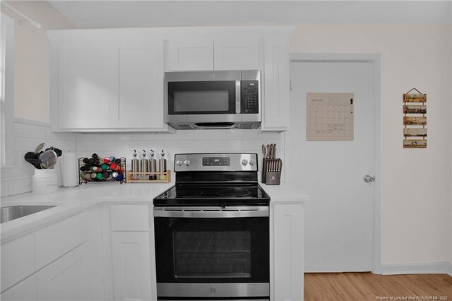 262 Shads Ford Blvd, Fayetteville, NC 28314 - kitchen with stainless steel appliances, light countertops, white cabinets, and tasteful backsplash