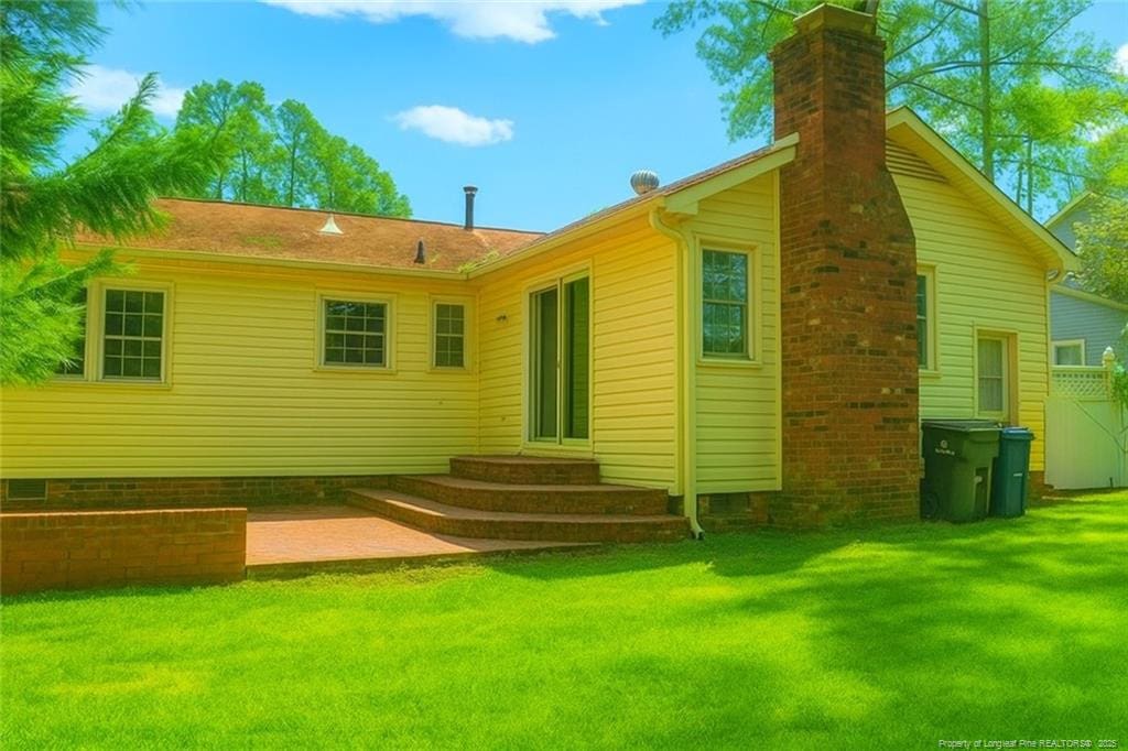 1609 Morehead Ave, Fayetteville, NC 28303 - rear view of house featuring a yard, entry steps, and a chimney