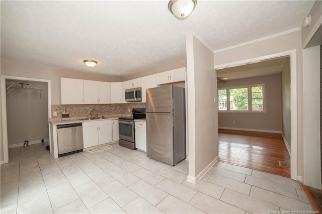 6310 Glenlea Cir, Fayetteville, NC 28314 - kitchen with stainless steel appliances, light countertops, white cabinets, tasteful backsplash, and a textured ceiling