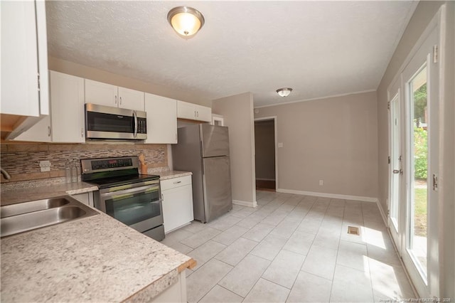 6310 Glenlea Cir, Fayetteville, NC 28314 - kitchen with appliances with stainless steel finishes, decorative backsplash, light countertops, white cabinets, and a textured ceiling