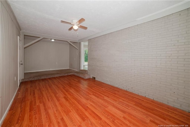 6310 Glenlea Cir, Fayetteville, NC 28314 - empty room with brick wall, light wood-style floors, a ceiling fan, and a textured ceiling