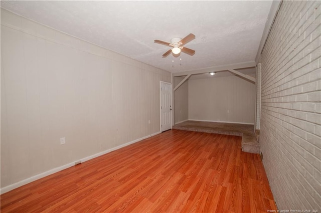 6310 Glenlea Cir, Fayetteville, NC 28314 - unfurnished room featuring a ceiling fan, light wood-type flooring, brick wall, and a textured ceiling