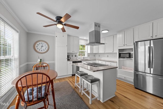 541 Mallie Pearce Rd, Zebulon, NC 27597 - kitchen with stainless steel appliances, island range hood, white cabinets, ceiling fan, and tasteful backsplash