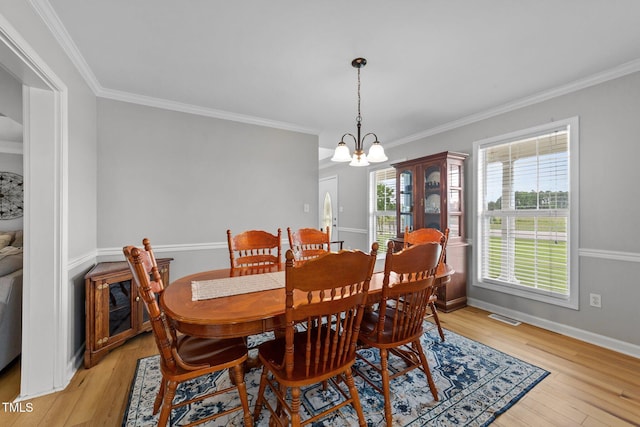 541 Mallie Pearce Rd, Zebulon, NC 27597 - dining space with a chandelier, crown molding, and light wood finished floors