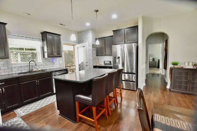 83 Mariners Point Way, Garner, NC 27529 - kitchen featuring stainless steel appliances, stone countertops, arched walkways, a center island, and plenty of natural light