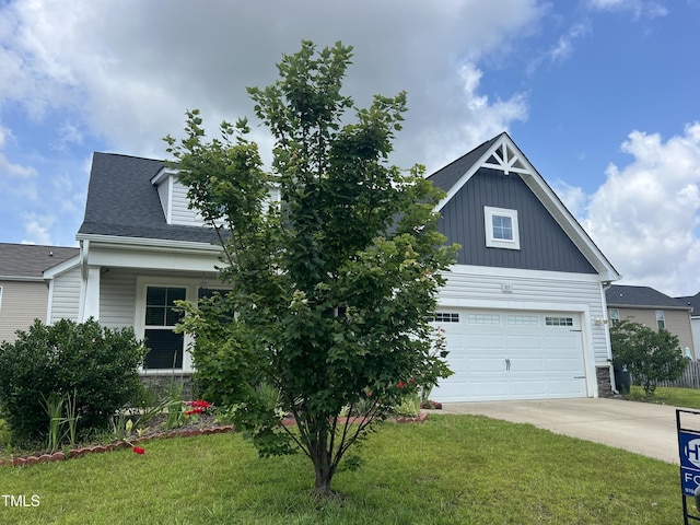 83 Mariners Point Way, Garner, NC 27529 - view of front of house featuring driveway, a front lawn, a garage, board and batten siding, and stone siding