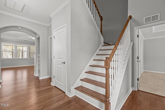 1172 Pemberly Ave, Morrisville, NC 27560 - stairway with arched walkways, ornamental molding, and wood finished floors