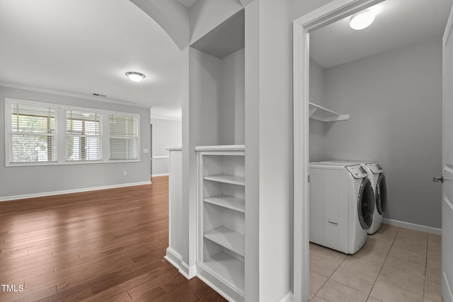 1172 Pemberly Ave, Morrisville, NC 27560 - laundry room featuring washing machine and dryer, ornamental molding, and light wood finished floors