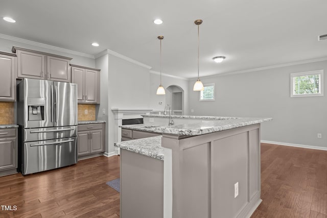 1172 Pemberly Ave, Morrisville, NC 27560 - kitchen featuring stainless steel refrigerator with ice dispenser, gray cabinets, plenty of natural light, tasteful backsplash, and ornamental molding
