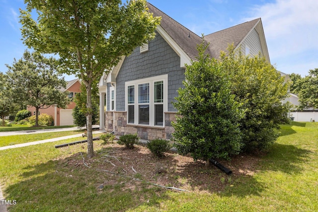 1172 Pemberly Ave, Morrisville, NC 27560 - view of side of property featuring a yard, stone siding, a garage, driveway, and roof with shingles