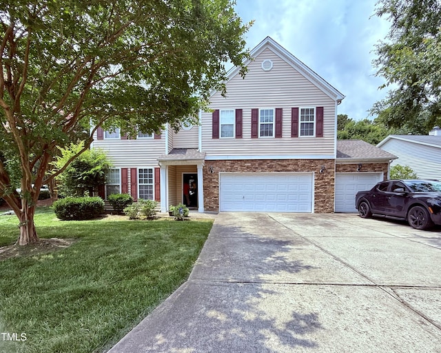 2228 Cedar Grove Dr, Durham, NC 27703 - view of front of home featuring driveway, a front yard, stone siding, and a garage