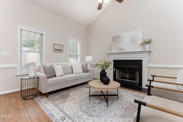 202 Chapel Valley Ln, Apex, NC 27502 - living room featuring wood finished floors, ceiling fan, a fireplace with flush hearth, and high vaulted ceiling