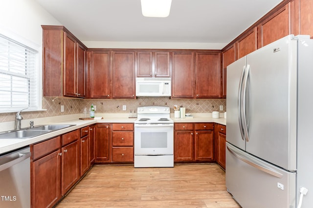 202 Chapel Valley Ln, Apex, NC 27502 - kitchen featuring appliances with stainless steel finishes, light wood-style flooring, backsplash, and light countertops