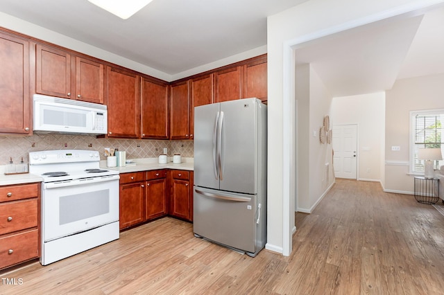 202 Chapel Valley Ln, Apex, NC 27502 - kitchen with white appliances, light wood finished floors, light countertops, backsplash, and brown cabinetry