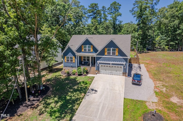 1176 Sagamore Dr, Louisburg, NC 27549 - view of front of house with driveway, a front lawn, covered porch, board and batten siding, and a garage