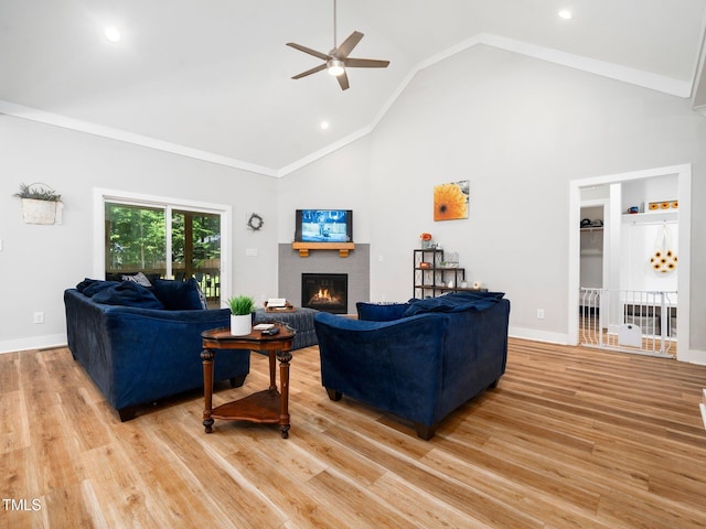1176 Sagamore Dr, Louisburg, NC 27549 - living area with a warm lit fireplace, ceiling fan, light wood-type flooring, high vaulted ceiling, and recessed lighting