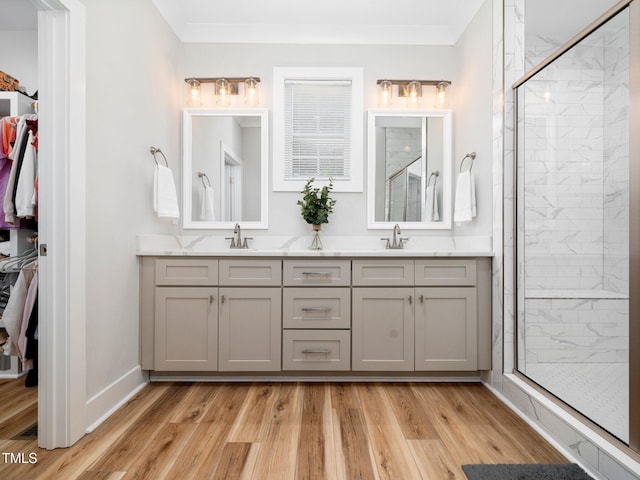 1176 Sagamore Dr, Louisburg, NC 27549 - bathroom with a spacious closet, double vanity, wood finished floors, a shower stall, and crown molding