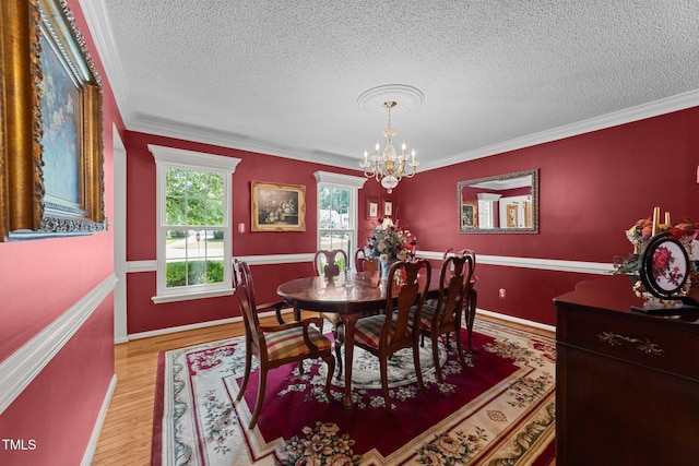 116 Lost Tree Ln, Cary, NC 27513 - dining room with a chandelier, a textured ceiling, ornamental molding, and light wood finished floors