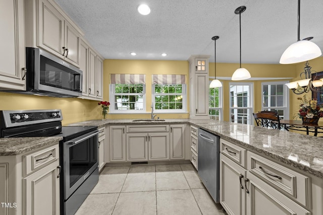 116 Lost Tree Ln, Cary, NC 27513 - kitchen with stainless steel appliances, a textured ceiling, hanging light fixtures, light tile patterned floors, and recessed lighting