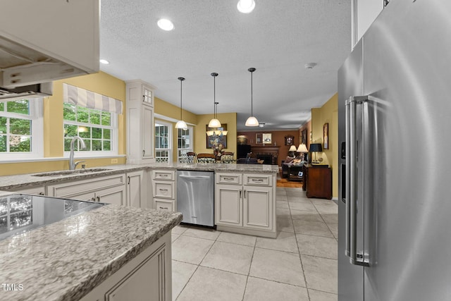 116 Lost Tree Ln, Cary, NC 27513 - kitchen with appliances with stainless steel finishes, open floor plan, a peninsula, a textured ceiling, and pendant lighting
