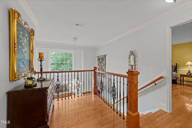 116 Lost Tree Ln, Cary, NC 27513 - hall featuring light wood-style floors, an upstairs landing, a textured ceiling, and ornamental molding