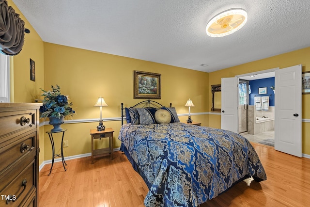 116 Lost Tree Ln, Cary, NC 27513 - bedroom with a textured ceiling, light wood-type flooring, and ensuite bathroom