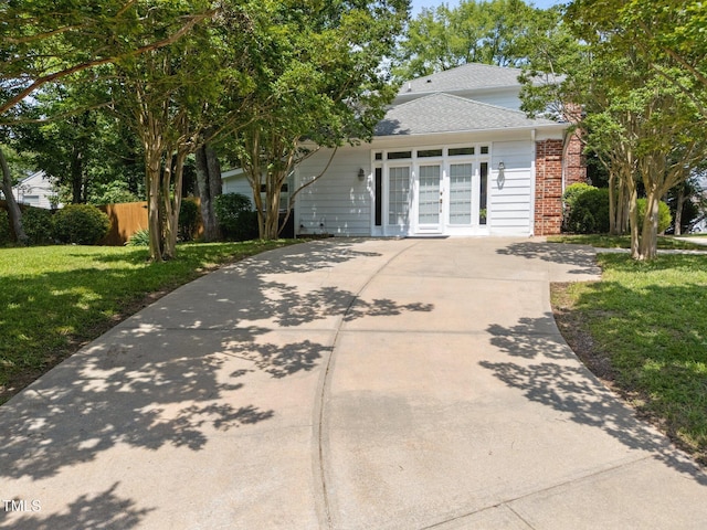 116 Lost Tree Ln, Cary, NC 27513 - view of front of house with brick siding, french doors, driveway, and a shingled roof